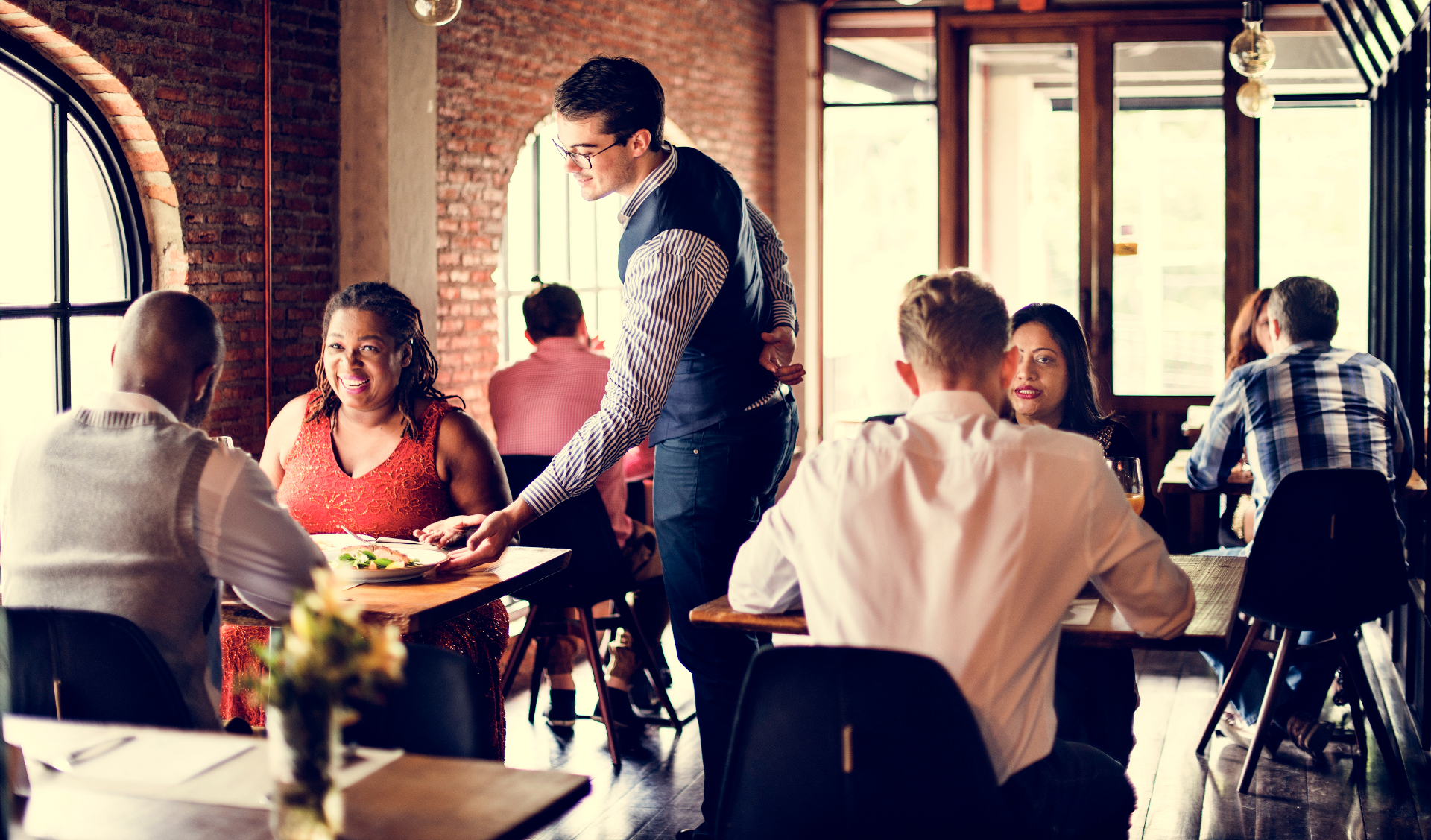 Restaurant dining scene with server providing excellent customer service